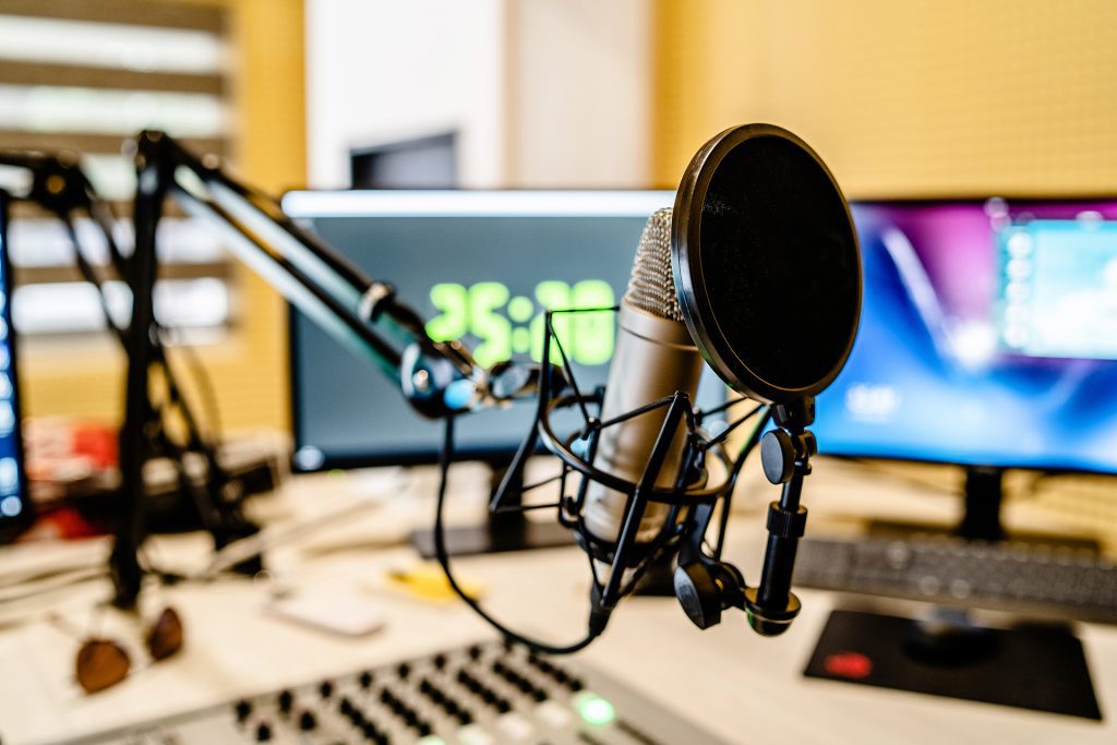 Microphone in a newsroom with 2 computer screens